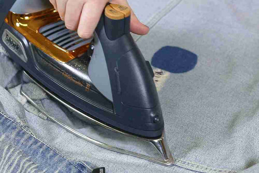 A person ironing a pair of jeans.