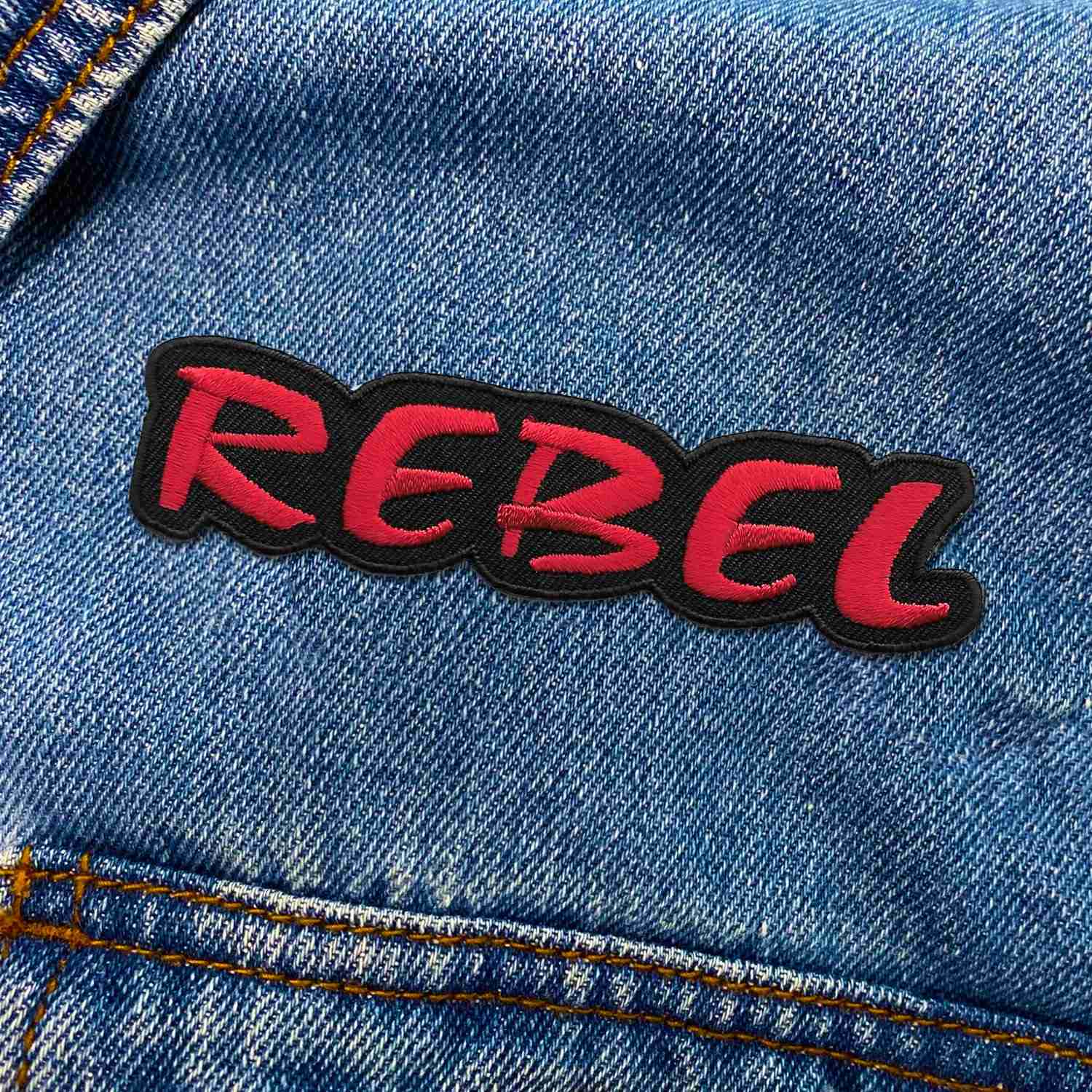 A denim jacket with the REBEL Iron on Patch on it.