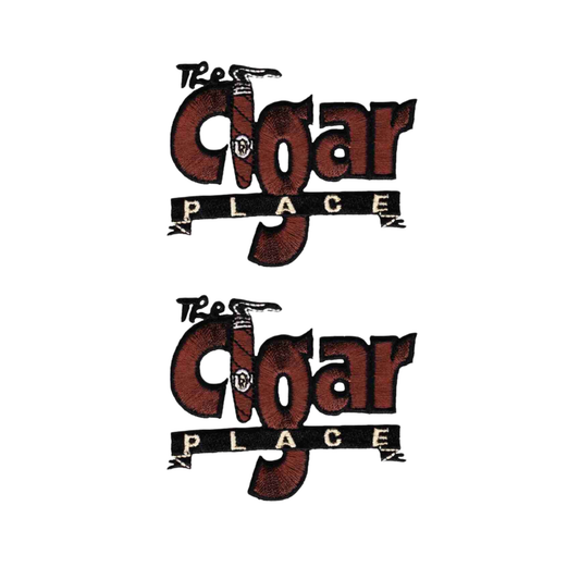 The Cigar Place (2-Pack) Iron on Patch by Laughing Lizards features two identical patches with a cigar-themed logo and a “PLACE” banner beneath “Cigar”—a distinctive design for any collection.