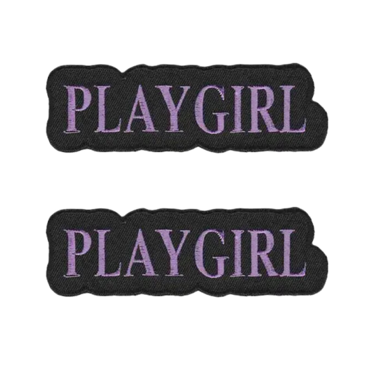 The LaughingLizards PLAYGIRL (2-Pack) Iron On Patch features two identical black patches with purple embroidery—ideal DIY accessories for your collection.