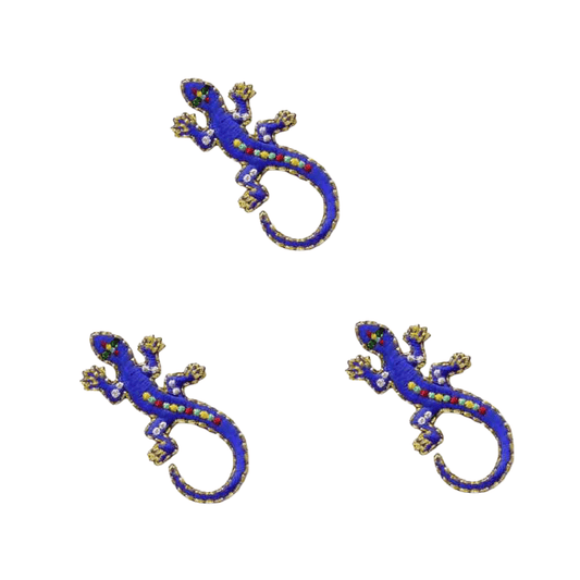 The Laughing Lizards Royal Blue Jewel Lizard (3-Pack) Reptile Iron On Patch features three decorative blue patches with colorful accents, arranged on a white background to create a playful lizard applique design.