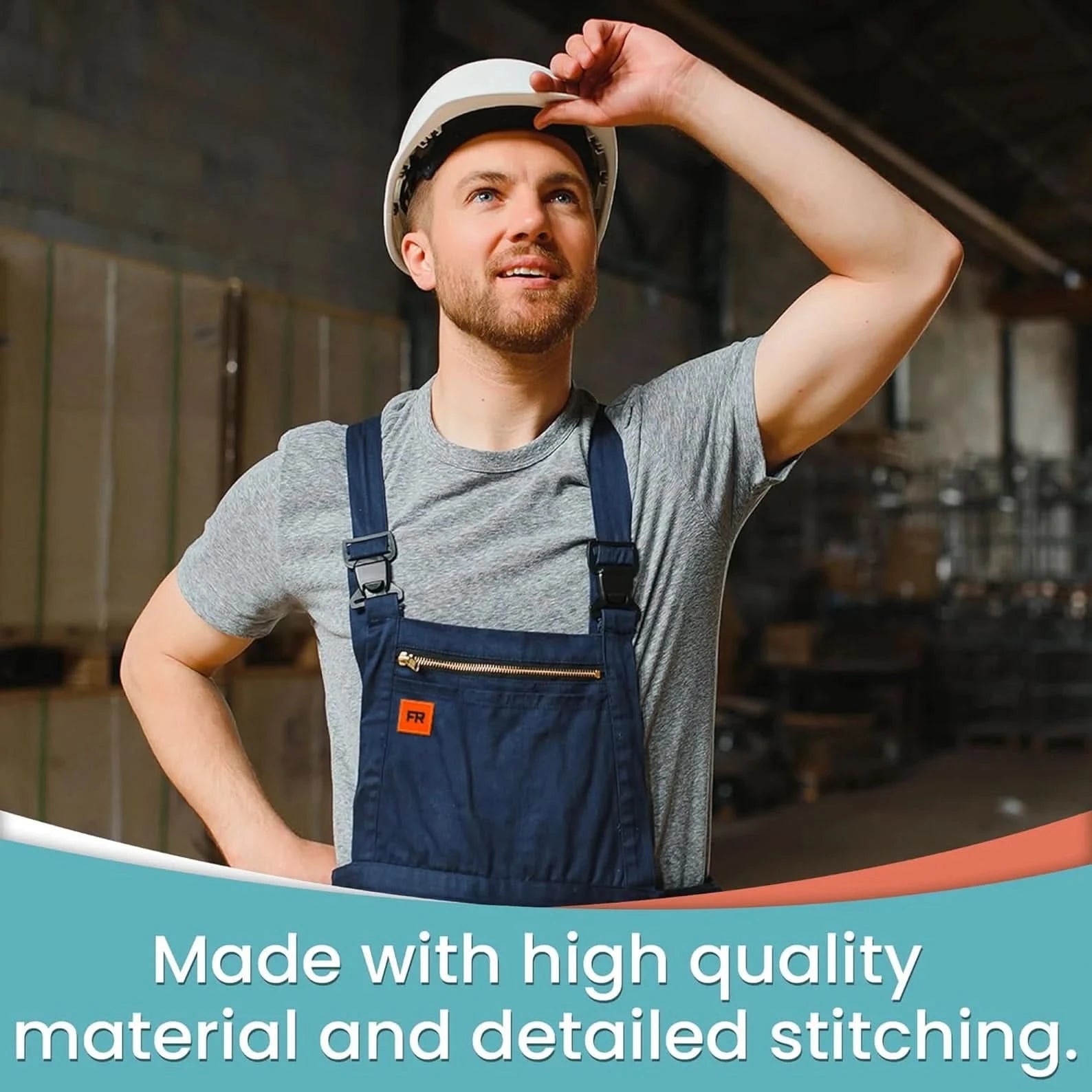 A man in a gray shirt, blue overalls, and white hard hat stands in an industrial setting. His uniform features a Laughing Lizards orange FR iron-on patch (10-pack), highlighting quality material and detailed stitching.