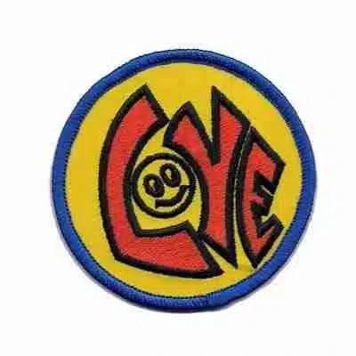 Add a pop of color to jackets or bags with Laughing Lizards' Love with Happy Face (2-Pack) Iron On Patch—yellow circle, blue border, red "LOVE" lettering with a smiley face "O." Fun, vibrant embroidered patches for easy application.