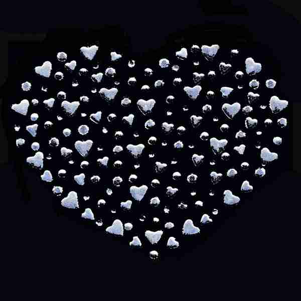 A Heart of Hearts Rhinestud Hotfix Iron On Applique shaped arrangement of small white hearts on a black background.