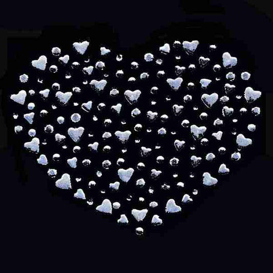 A Heart of Hearts Rhinestud Hotfix Iron On Applique shaped arrangement of small white hearts on a black background.
