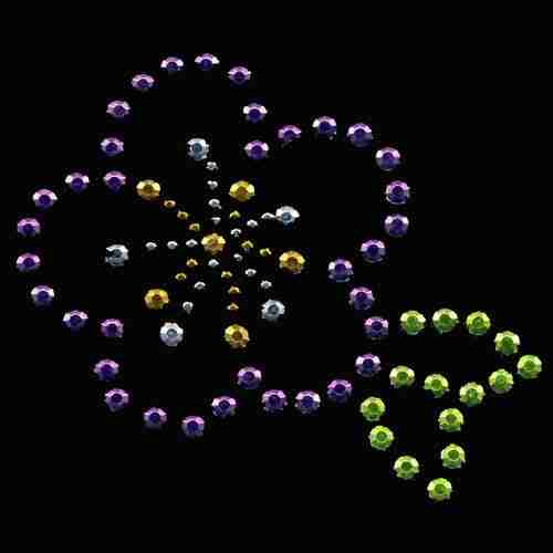 A Purple Hibiscus Rhinestud Flower Hot Fix Applique made of beads on a black background.