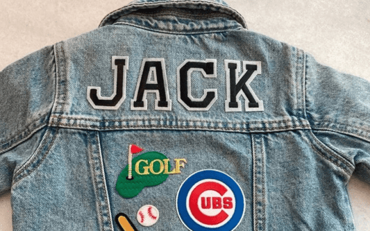 Denim jacket with "JACK" text and patches featuring golf, baseball, and the Cubs logo on the back.
