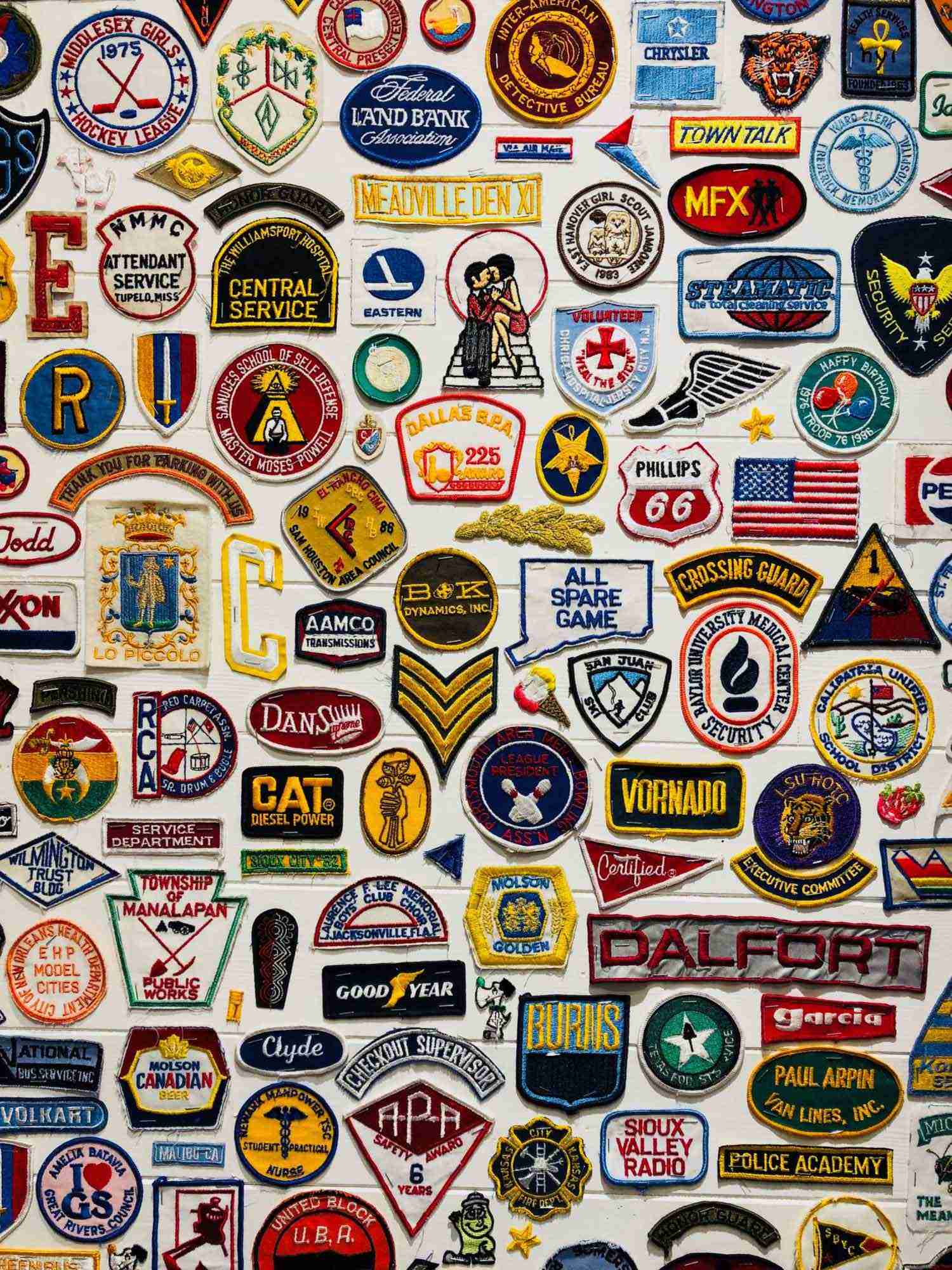 A collage of many different types of Iron on Patches badges.
