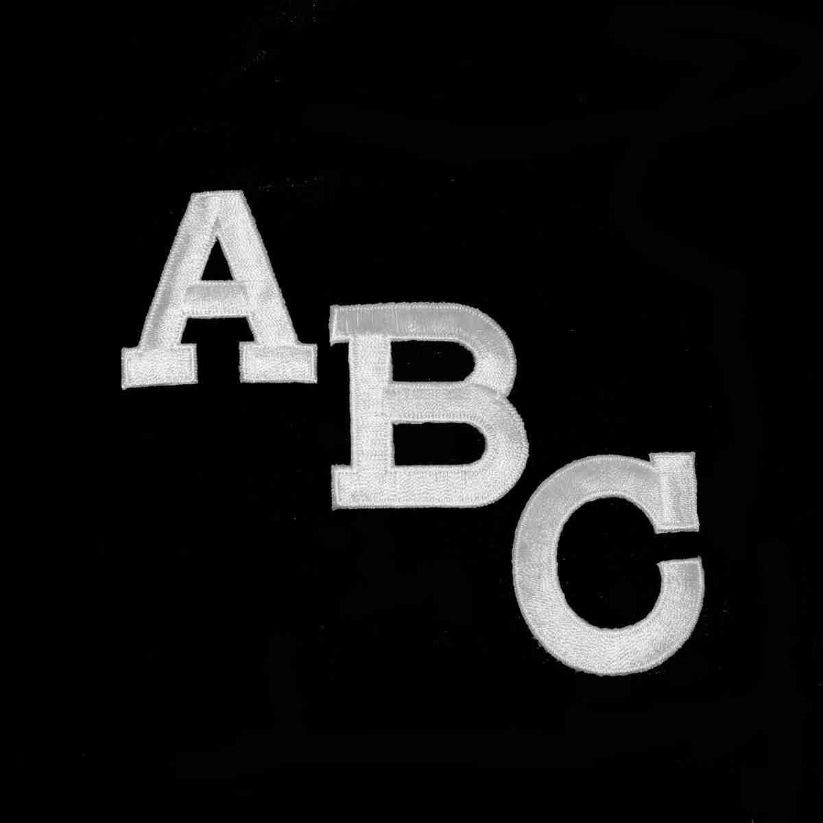 A black and white photo of the Block Letters- WHITE Iron On Letters (2"H) Sold Separately on a black background.