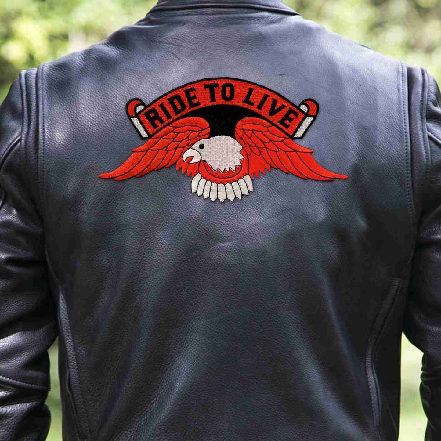 A man wearing a leather jacket with a Ride to Live Orange Eagle Backpatch Iron On Patch on it.