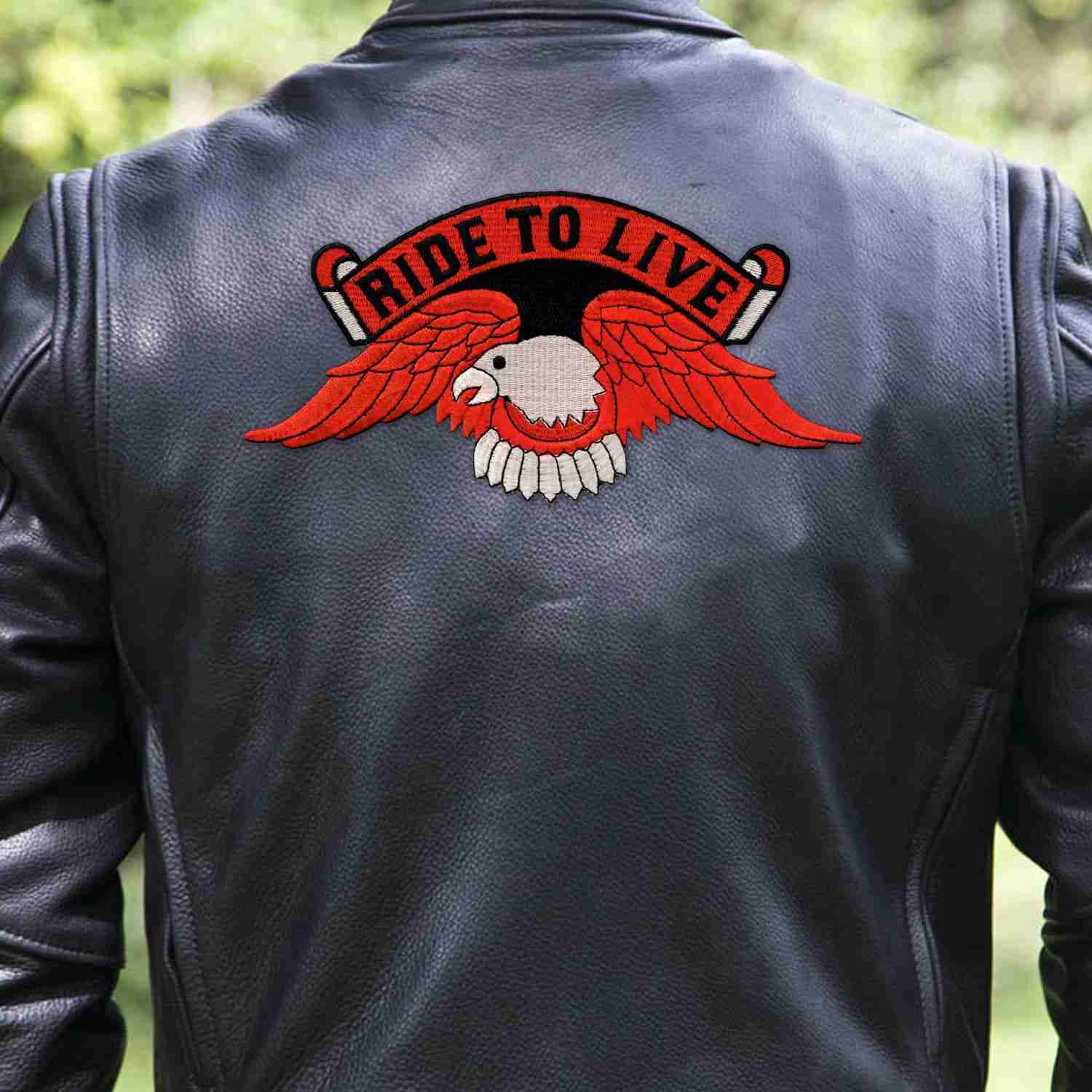 A man wearing a leather jacket with a Ride to Live Orange Eagle Backpatch Iron On Patch on it.
