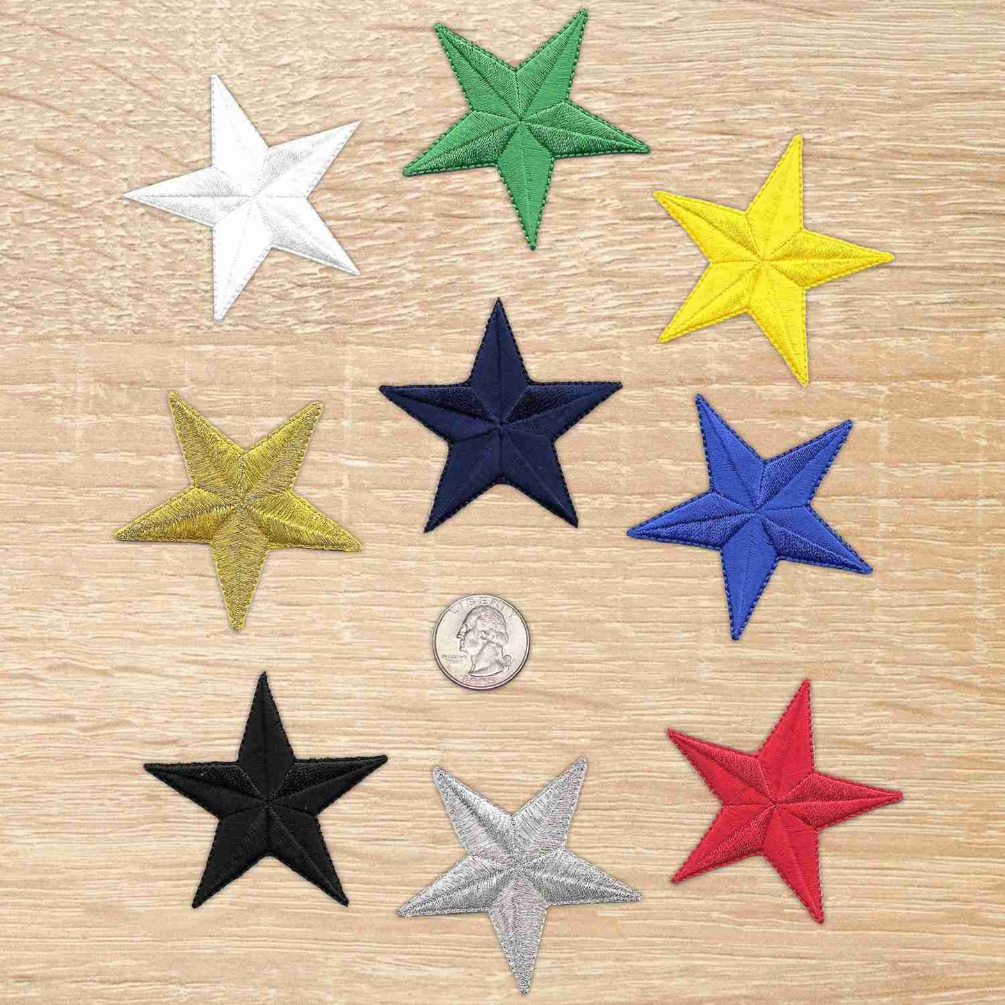 Six 2.5 Inch Star Iron On Patch (5 Pack) appliques on a wooden table.