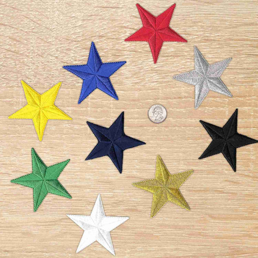 Five 3 Inch Iron on Star Patches (5 Pack) appliques on a wooden table.