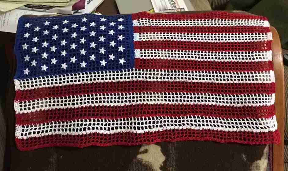 A crocheted 3 Inch Iron on Star Patches (5 Pack) sitting on a chair.
