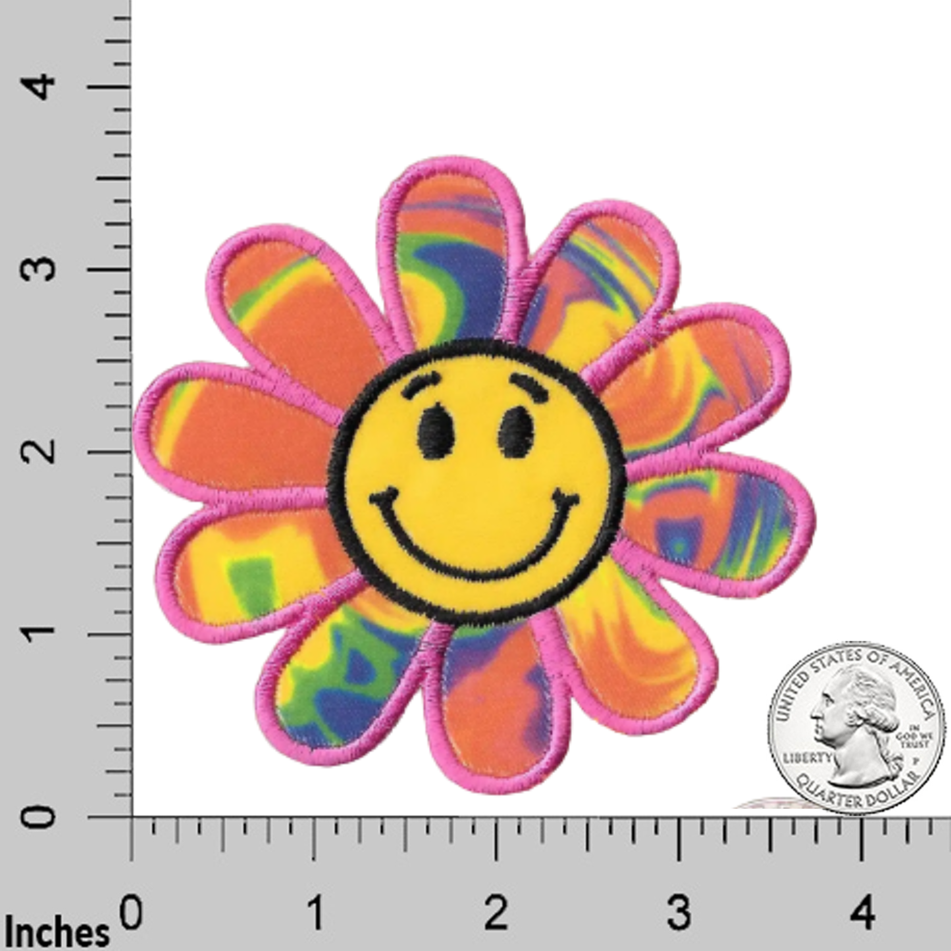 The Laughing Lizards Happy Face Rainbow Daisy (2-Pack) Embroidered Flower Iron On Patch features tie-dye petals and a yellow smiley face center—perfect for adding retro flair to jackets, bags, or jeans. Shown next to a ruler and U.S. quarter for scale.