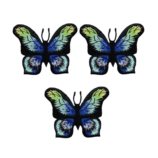 The Laughing Lizards Butterfly Blue Morpho-like Iron On Patch 3-Pack features three embroidered butterfly patches in black, blue, green, and yellow, arranged in a triangle on a white background.
