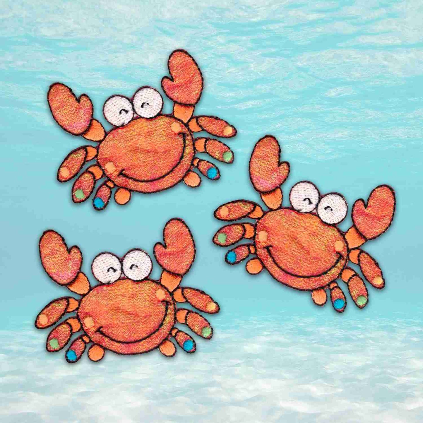 Three Crab Patches (3-Pack) Sea Animal Embroidered Iron Patch Appliques floating in the water.