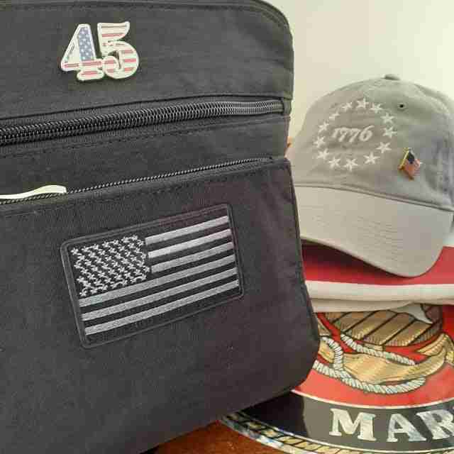 A bag with Black & Gray USA Flag Patches (2-Pack) American Flag Embroidered Iron On Appliques on it and a hat.