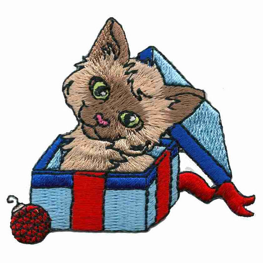 The Christmas Kitty in a Present Iron On Patch by Laughing Lizards features a smiling cat with green eyes in a blue gift box, holding a red yarn ball—perfect as a DIY craft applique or festive Christmas cat patch.